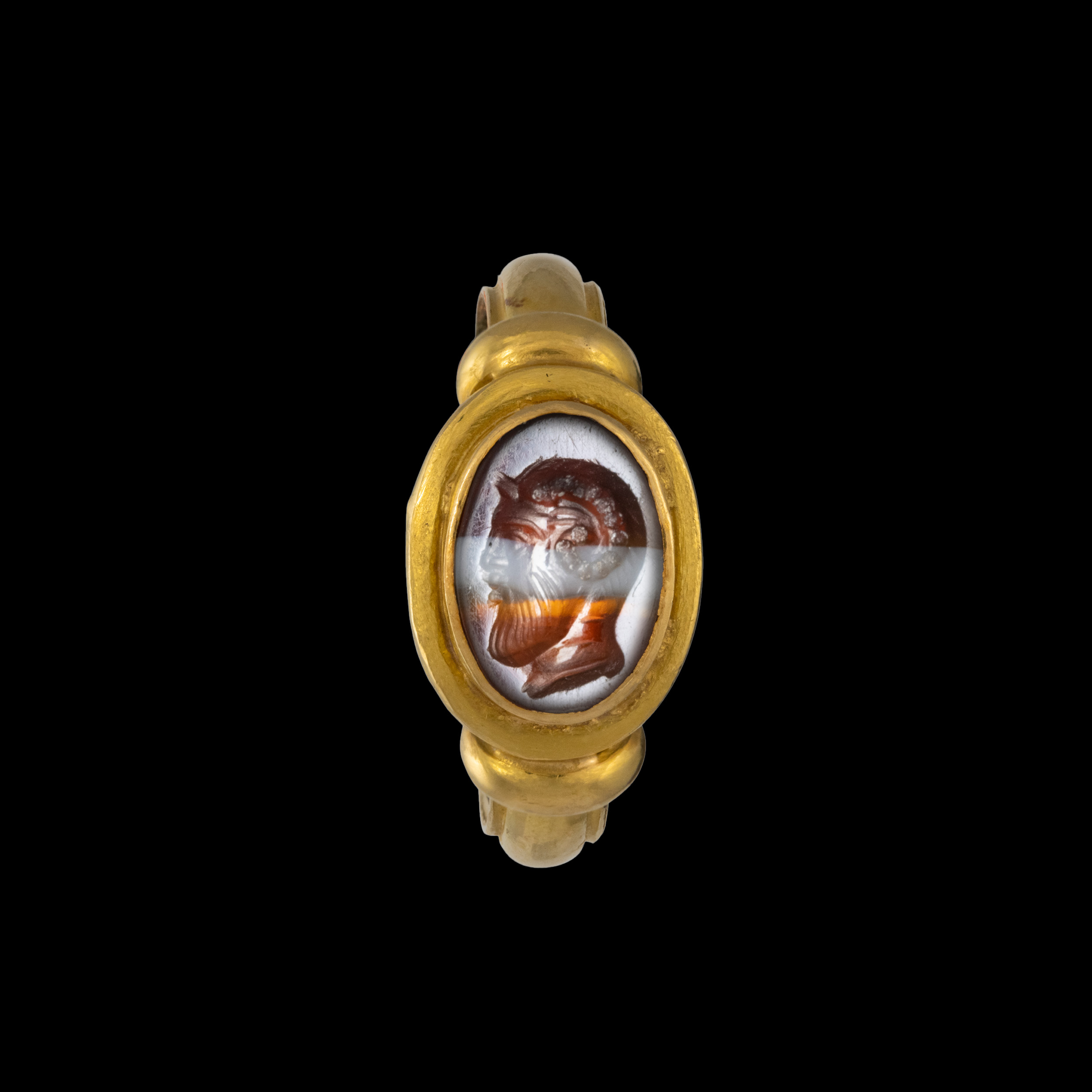 A high carat gold ring set with an  Italic banded agate intaglio. Head of Amon 